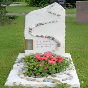 cavurne en pierre nettoyée et fleurie avec fleurs de saison